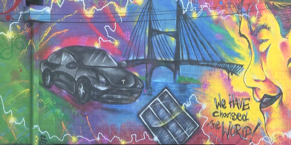 A colorful mural featuring a car, bridge, solar panel, and text saying 'We have changed the world!'