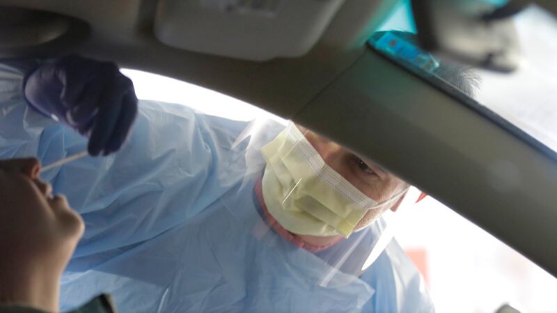 A nurse at a drive-up coronavirus testing station set up by the University of Washington...